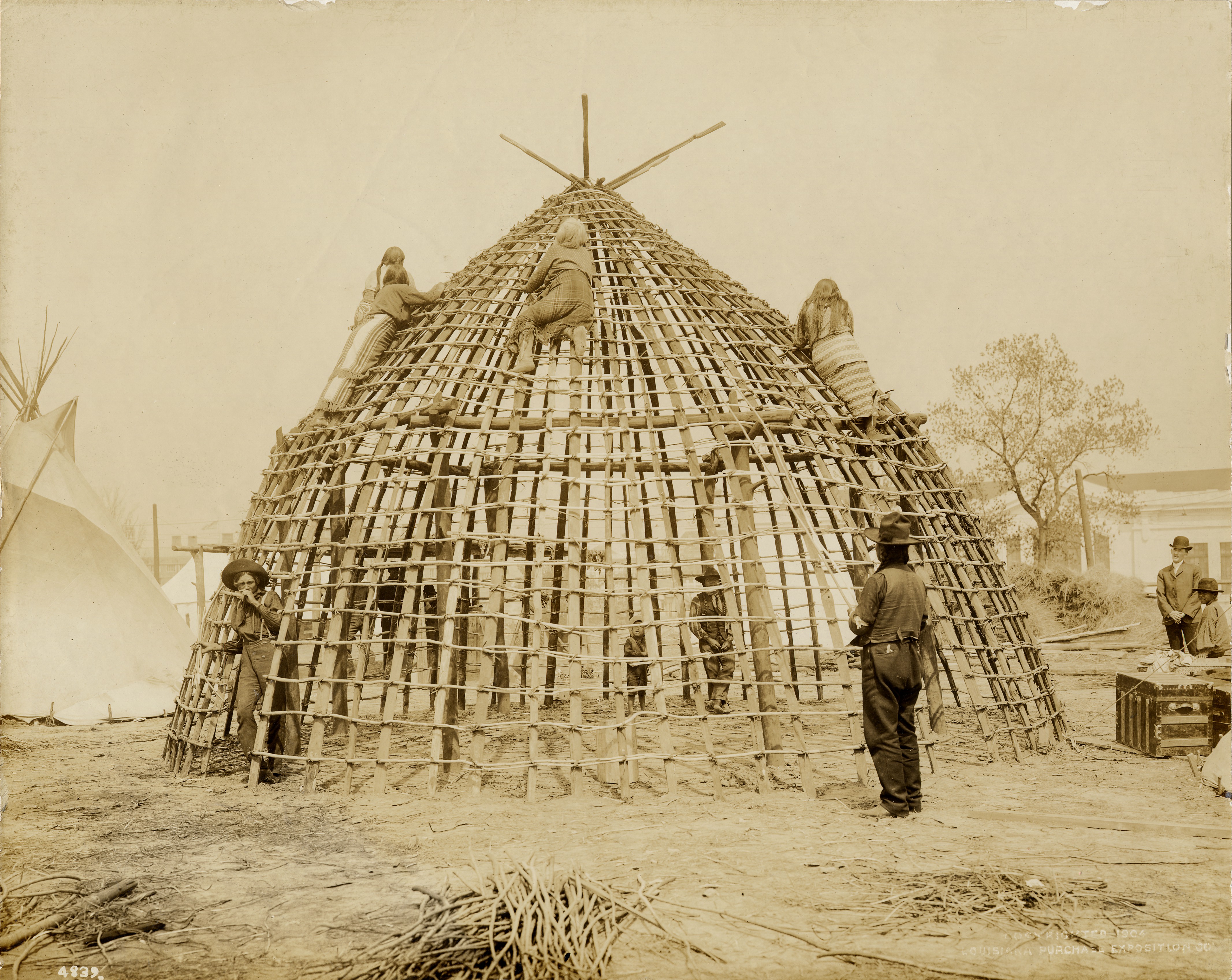 Wichita (Taovaya-Caddoan) people constructing a traditional grass lodge at the 1904 World's Fair — contextual image for the Wichita-Caddoan ancestors who fortified the Spanish Fort site on the Red River